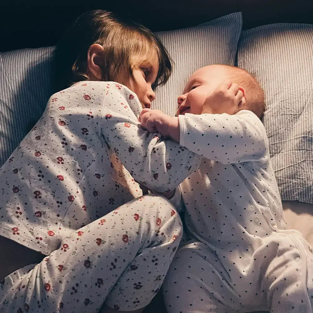 Baby und Mama liegen im Bett Babyschlaf Abendroutine baybies Blogbeitrag